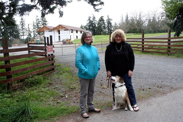 Maro Walsh and Asara Lovejoy stand across the street from their South Whidbey homes Monday. Comforts of Whidbey winery is building an event center