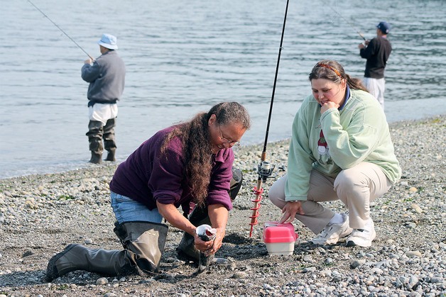 Bonnie Nichols holds a pink salmon she just landed at Bush Point on Aug. 13 with her daughter