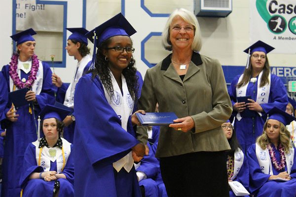 Elshadai Hailu receives her diploma cover from board Chairwoman Linda Racicot during Saturday