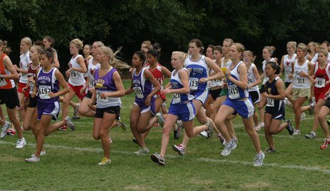 Falcons Lillianna Stelling and Nora Felt (numbers 1421 and 1415) join hundreds of fellow athletes at the start of their 3.1-mile race during the South Whidbey Invite on Saturday. A watermelon-sized beehive on the course delayed the race for a half-hour.
