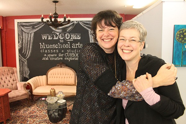 Karin Bolstad hugs Tammi Sloan in the main classroom and gallery space of Blueschool Arts in Clinton. Bolstad’s arts collective had its first gala last weekend.