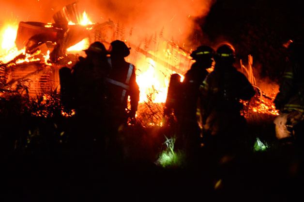 South Whidbey Fire/EMS firefighters work to douse a fire that burned a Clinton barn last week.