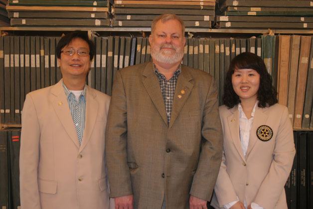 Korean visitors Byoung-Kil Son (left) and Keun-young Song pose with South Whidbey Rotary Club member Bill Lewis in front of the local paper’s archives dating back to the late 1800s.