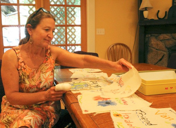 Josette Hendrix examines some of the muslin flags which will be hung up in downtown Langley.
