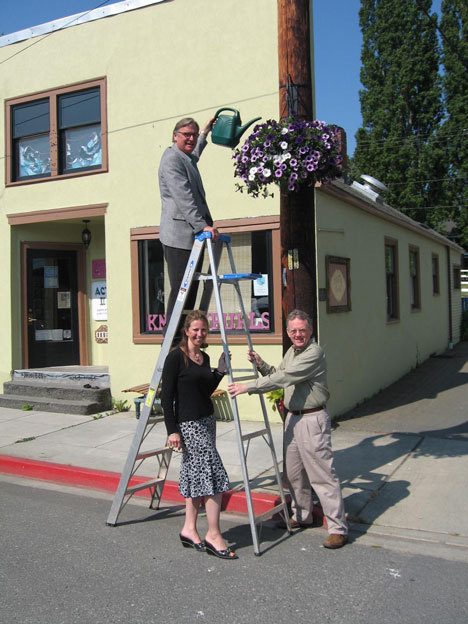 Langley Mayor Paul Samuelson practices his watering technique on one of the city’s new hanging baskets. Assisting are Langley Chamber of Commerce Director Sherry Mays and Puget Sound Energy’s community representative  Walt Blackford.