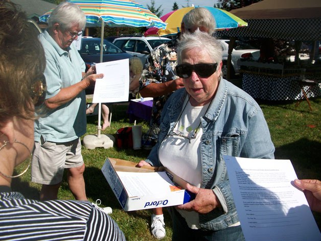 Beverly Rose makes sure that just about everyone at the Clinton Thursday Market walks away with a credit union survey in their hands.