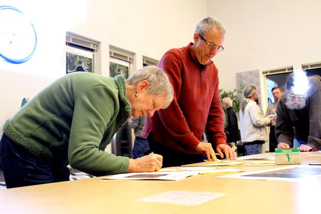 Ann Sullivan of Greenbank and Langley resident Tim Legree fill out sticky notes with their thoughts and opinions of three state-owned properties at the Washington State Parks meeting on Thursday night at Whidbey Water Services in Freeland.
