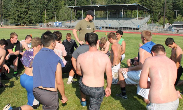 South Whidbey Falcon football assistant coach Alex Heilig gathers players after a recent optional conditioning day before Aug. 20