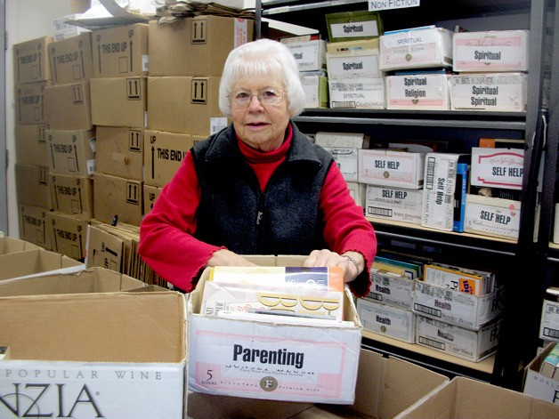 Joan Nelson sorts books in the building named in honor of her late husband
