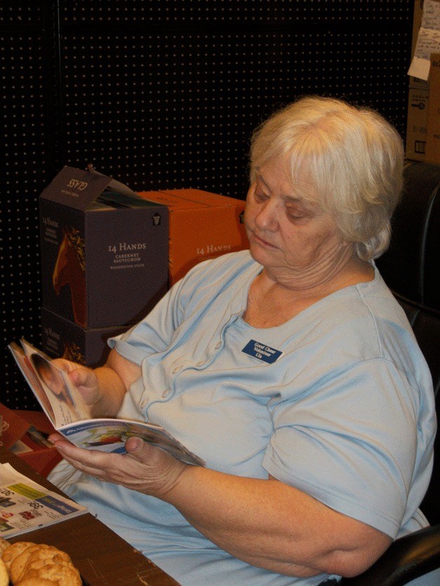 Ula Lewis sorts through the club’s community file of available coupons. She uses the savings to help the Good Cheer Food Bank.