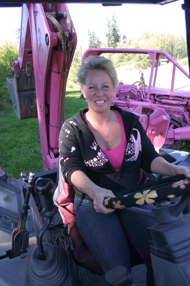 Elaine Damerau drives her pink loader/backhoe through the gravel and dirt pit at Andrew’s Landshapers in Freeland to increase awareness about breast cancer. October is National Breast Cancer Awareness Month.