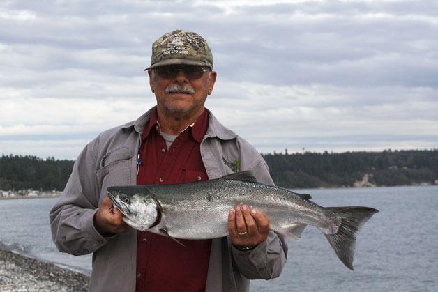 Bruce Silvia of Coupeville shows off a silver salmon he caught at Driftwood Park in Coupeville in late September. Coho fishing will be closed this year in waters around Whidbey due to lack of fish.