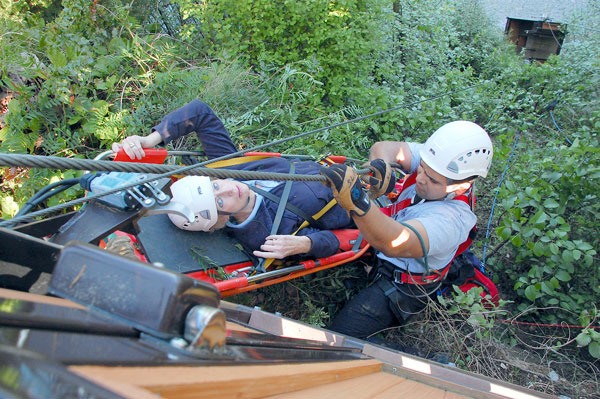 Oak Harbor Firefighter Rich Cuevas helps Greenbank resident Sheila  Chidsey to safety from the cliff in front of her high-bank home on North Bluff Road.