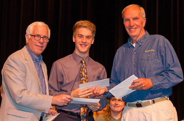 Kiwanis of South Whidbey members Bob Welch and Ron Myers present Gavin Imes with a scholarship letter at the South Whidbey High School scholarship night May 29.