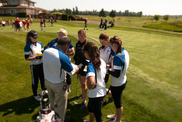 South Whidbey's girls golf team gathers around coach Tom Sage before the 1A District 1 golf tournament. South Whidbey edged its Cascade Conference rival King's to win the district crown