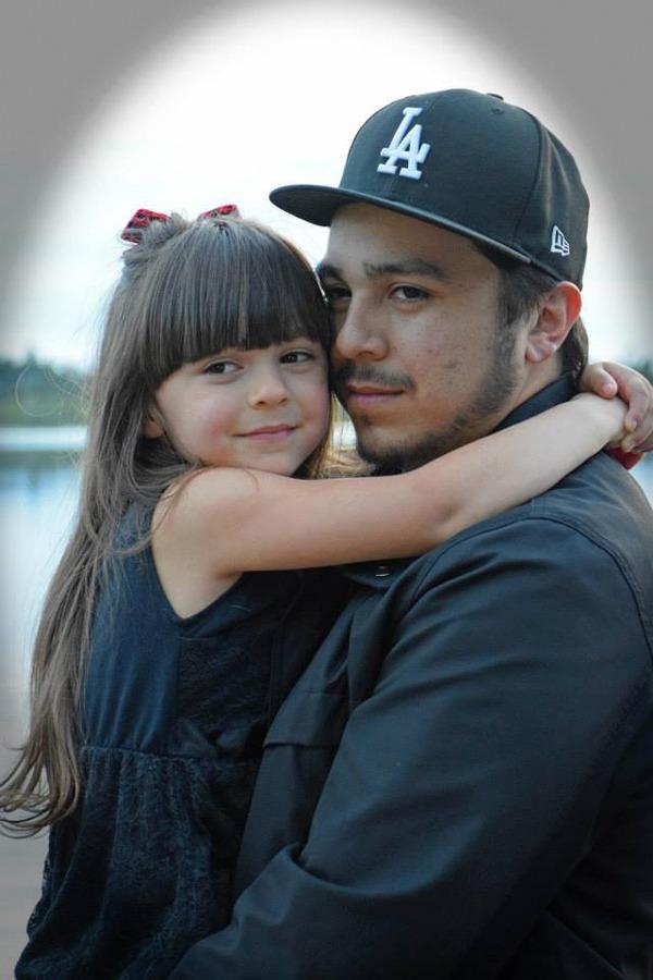 Shooting victim Adam Garcia is shown holding his daughter