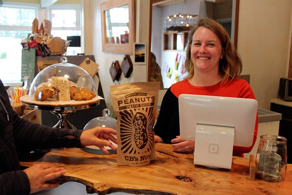 Janae Cameron of MAKE Whidbey Market in Clinton smiles while helping a customer. She's celebrating a year in business in a community where others have packed up shop and left for new locations.