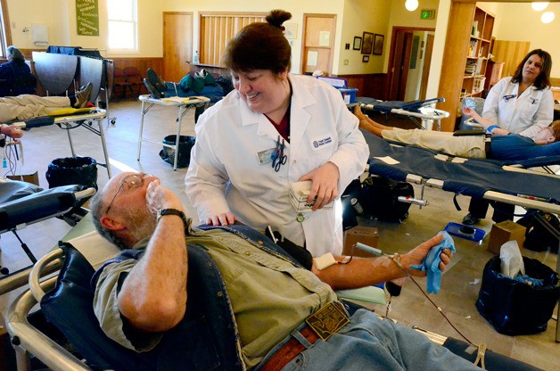 Coupeville resident Mike Millenbach shares a laugh with Puget Sound Blood Center phlebotomist Becky Brown at a blood drive this week. Millenbach gives blood regularly and knows Brown from previous visits. He’s given nearly three gallons over the years.