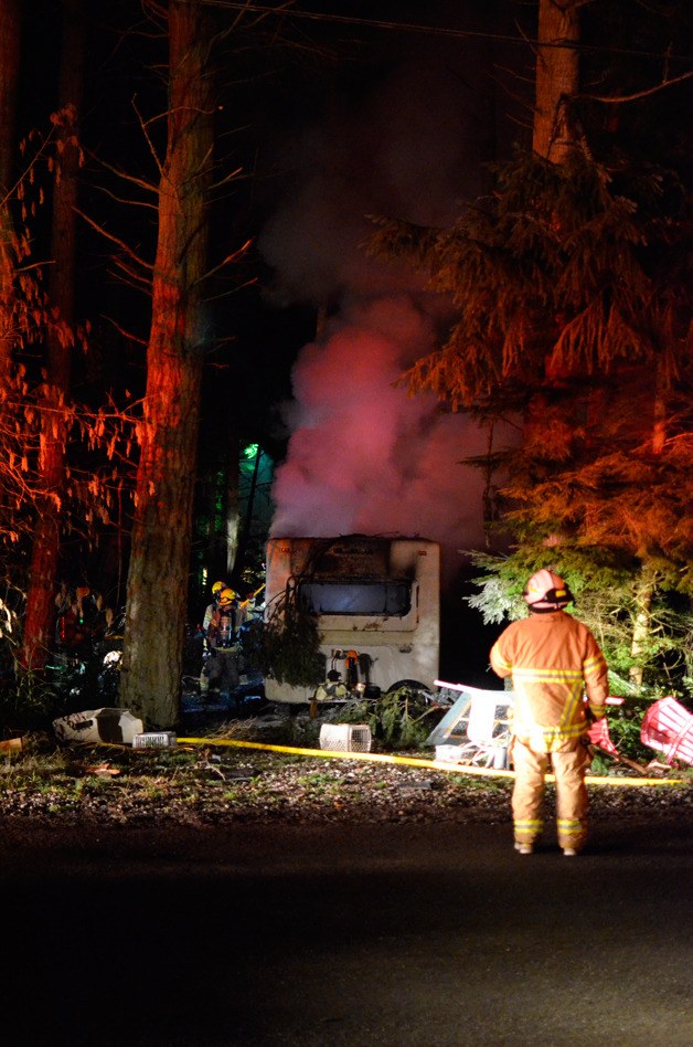 South Whidbey Fire/EMS personnel inspect the smoldering remains of a mobile home that caught fire.