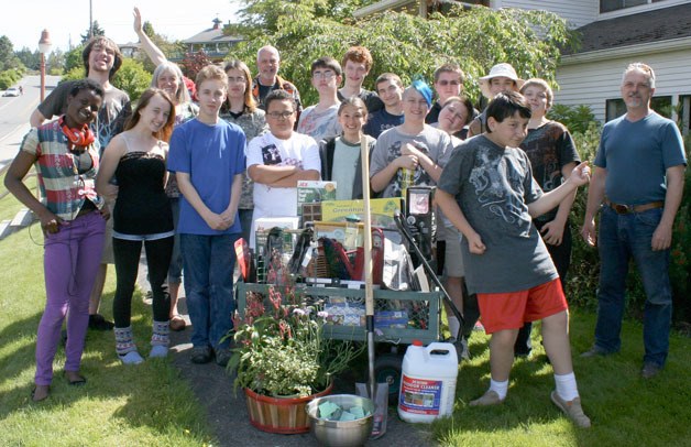 South Whidbey youths huddle around the garden cart comprised of donated items worth more than $800. The cart brought in about $600 for the after-school hangout in Langley. In the first row