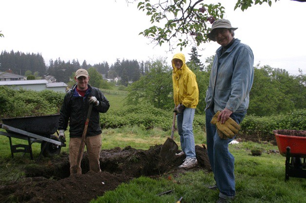 A Hearts & Hammers crew digs in to help fix a drainage area at a Clinton home during last year's May workday.