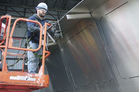 Kelley Lashley works Monday on a section of the pilot house for a new 64-car ferry being built for the state of Washington by Nichols Brothers Boat Builders of Freeland. The company plans to bid to construct three more of the vessels.