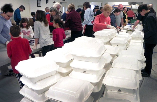 Volunteers prepare and package meals on Thanksgiving Day at St. Hubert Catholic Church in Langley. A host of help made a record 380 meals that were distributed across Whidbey Island.