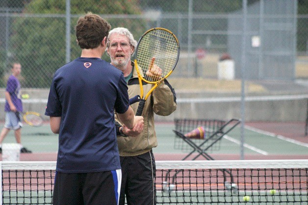 Tom Kramer instructs South Whidbey High School junior Chase Collins on the proper volleying technique during a recent practice. Kramer coached the boys tennis team for more than 30 years before resigning in August.