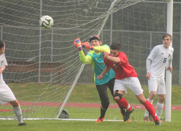 Falcon senior keeper Charley Stelling gets position against King’s senior Svenn Helleren during a corner kick April 3.