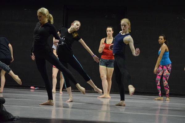 Dancers Kelsey Lampe and Sierra Schallock practice a contemporary dance move with professional dancer Joy Spears.