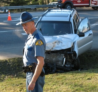 Trooper Norm Larsen gathers information after a KIA sport  utility vehicle and Ford pickup truck collided at the  intersection of Cultus Bay Road and Highway 525 Sunday afternoon.