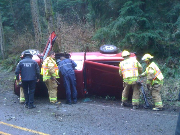 South Whidbey emergency personnel help the driver of this pickup which left Surface Road and rolled over on its side Wednesday afternoon. The driver apparently was uninjured