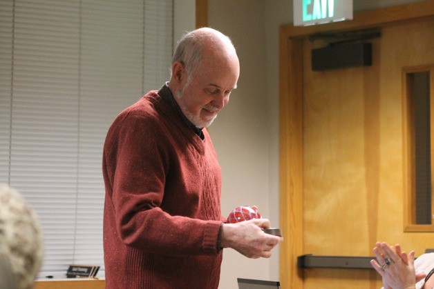 Langley City Councilman Jim Sundberg looks down at a parting gift from City Hall