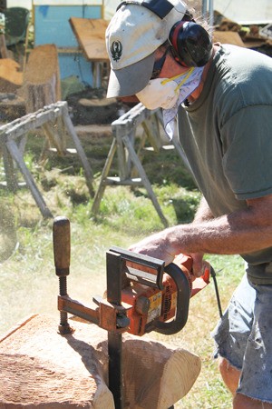 Pat McVay cuts a piece of wood to be used in a floral dogwood bench