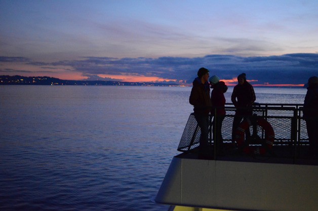 Justin Burnett / Record file People enjoy an evening ferry ride in this photo from December 2013. Late-night sailings may be cut.