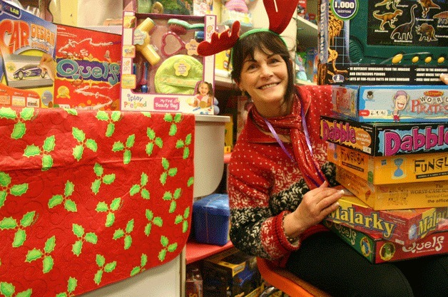 Holiday House volunteer Joan Smith displays a selection of the latest games available as gifts for those who need them. “It’s just wonderful