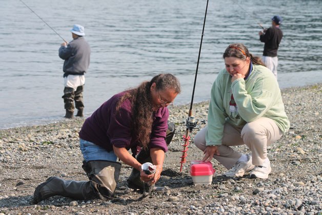 Bonnie Nichols dispatches a salmon at Bush Point in August with her daughter Stacie Lanners. Happy anglers like these may be hard to find in 2016.