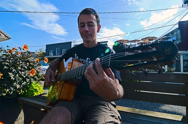A DjangoFest Northwest participant strums an impromptu tune in downtown Langley during last year’s festival.
