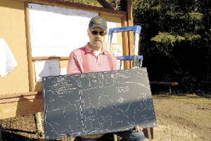 Jerry Lloyd shows off the etched sign that will be placed at the Putney Woods trailhead kiosk.