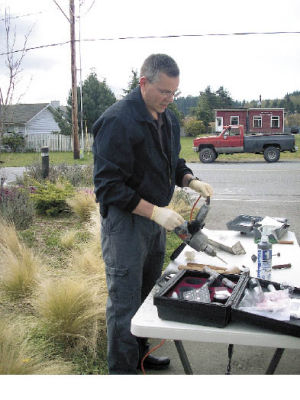 Sheriff Deputy Phil Farr dusts a power drill that was left behind at the laundromat during the break-ins early Thursday morning. Police took tools into evidence that were left behind at every  location hit by the thieves.