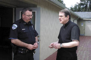 Langley Police Officer Randy Heston and Father Rick Spicer discuss the damage done at St. Hubert Catholic Church Thursday morning. Police arrested two suspects.