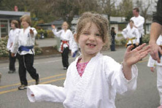 Michaela Marx Wheatley/ The Record  A young martial arts student from Tiger Martial Arts waves to the spectators.