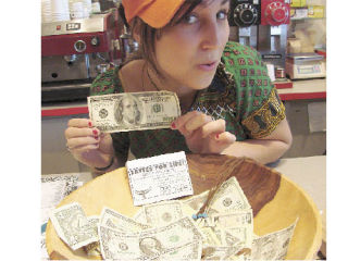 Lattés for Life organizer Laurel Johnson shows off a “Ben Franklin” $100 bill