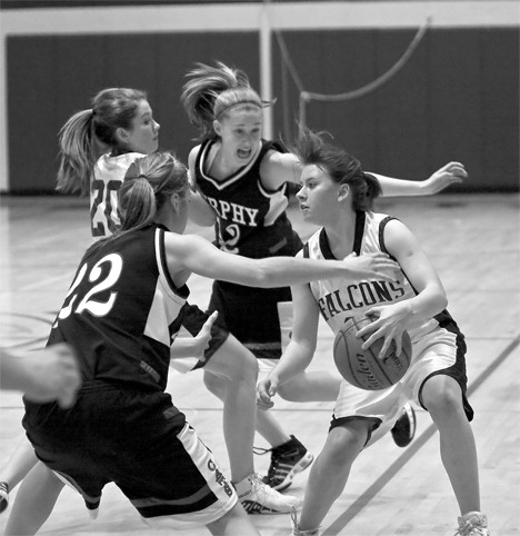 Falcon guard Chantal LaChaussee makes a valiant effort to get the ball past the Wildcat defense and score Tuesday as teammate Reilly OSullivan closes in to help.