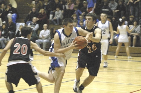 Parker Barnett dodges a bullet as he avoids Wildcat defenders Jared Smith and Ryan Bourke during South Whidbeys 58-40 victory over Archbishop Murphy.