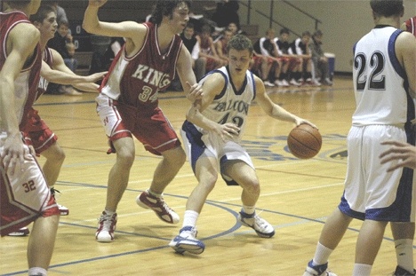 Falcon Eric Stallman does his best to avoid the long reach of Kings 6-foot-7 center Dylan ONeil during Tuesdays 65-36 loss to the undefeated Knights. ONeil led scoring with 21 points.