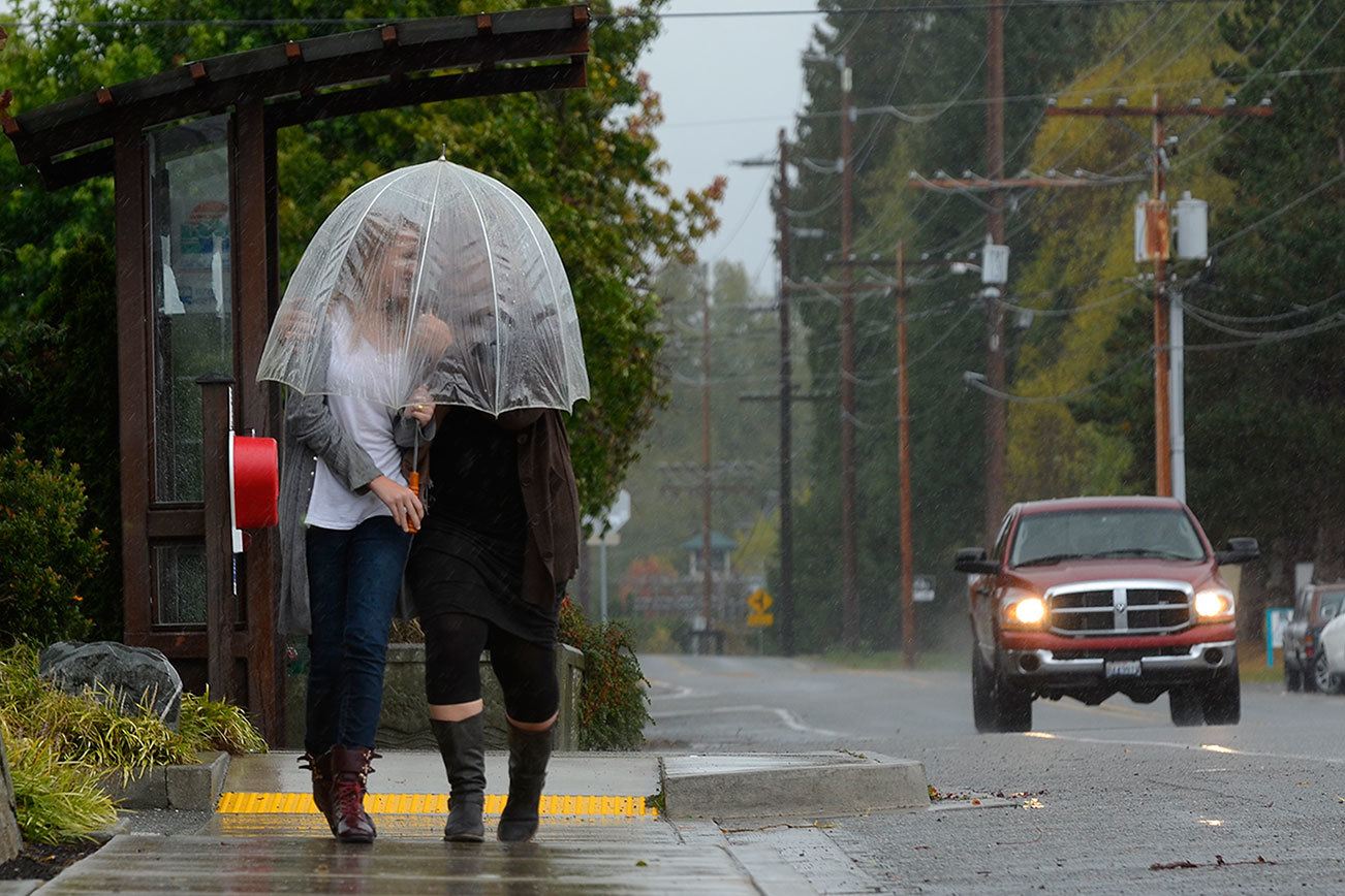 Mother and daughter Ada Rose Faith-Feyma and Sheila Weidendorf of Langley walk down Main Street in Freeland Friday for a cup of joe at WiFire Cafe. Others on South Whidbey were busy preparing for the coming storm, buying batteries and other emergency supplies.