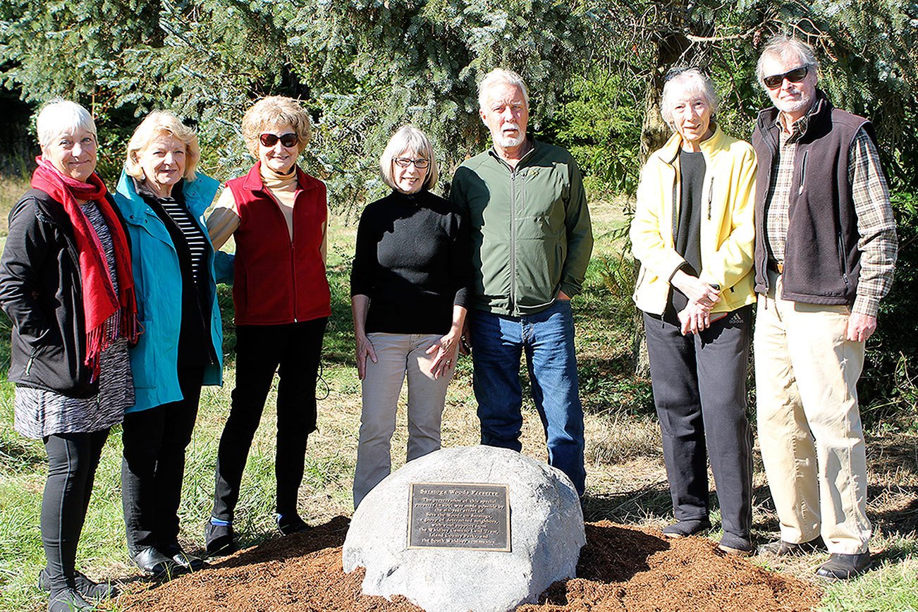 Evan Thompson / The Record South Whidbey community members recently gathered to celebrate the installation of a plaque and boulder that commemorates the six-year effort of a group that prevented Saratoga Woods from being developed into a 200-room resort. From left to right: Sharon Emerson, Cynthia Tilkin, Diane Kendy, Kim Drury, Charlie Snelling, Betty Azar and Larry Harris.