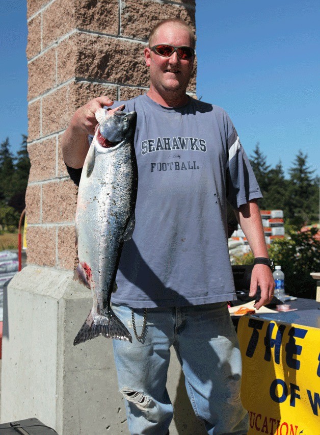 Robert Mills holds his third-place winning 6.76-pound pink salmon after weigh-in at the Whidbey Island Pink Salmon Derby Saturday.