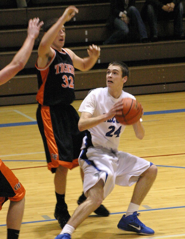 South Whidbey senior captain Ben Cary pump-fakes on his drive against Granite Falls junior guard Jeff Benson. The Falcons’ offense overpowered the Tigers for a 62-51 victory.